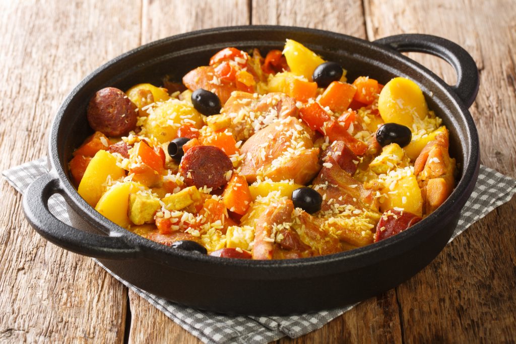 Chinese food Galinha a Portuguesa of chicken with chorizo vegetables in coconut curry close-up in a pan on the table. horizontal